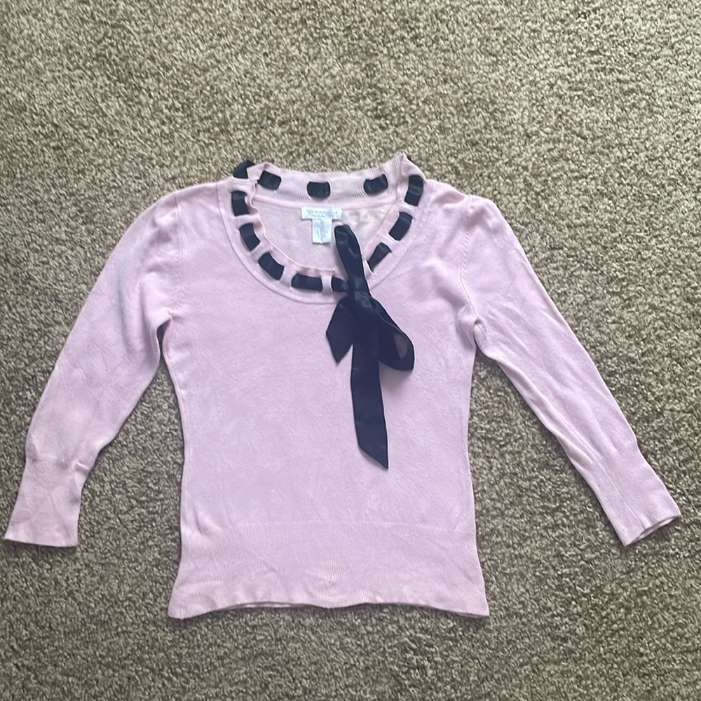 Pink sweater with black tie along neckline